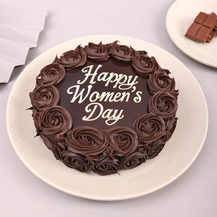 Women's Day chocolate cake with rose-shaped frosting and 'Happy Women's Day' message