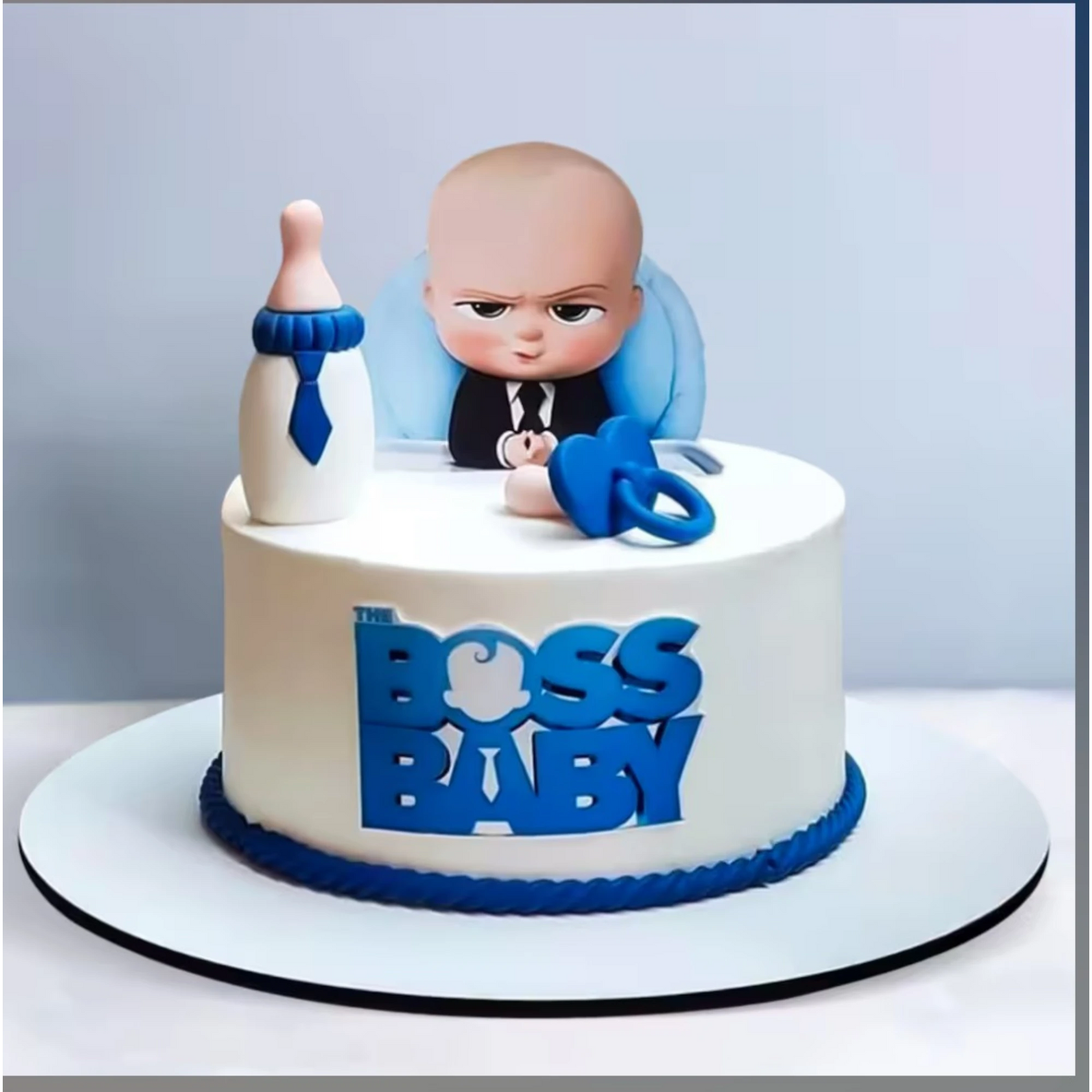 Blue and white birthday cake with 'The Boss Baby' text and character design