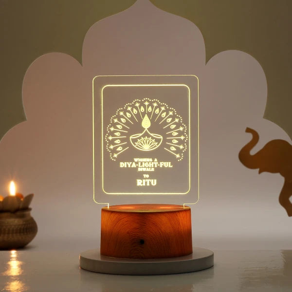 Decorative Diwali LED Lamp with engraved acrylic panel and wooden base, glowing warmly for festive home decor and gifting.