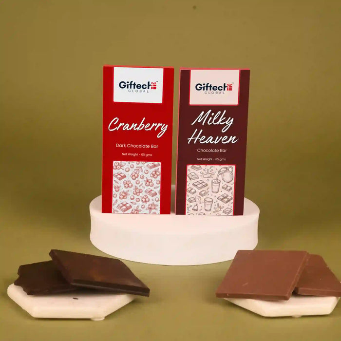 Mixed Berries Milky Chocolate Duo 65g featuring two chocolate bars—Mixed Berries and Milky Heaven—on a display with chocolate pieces. Ideal for gifting.