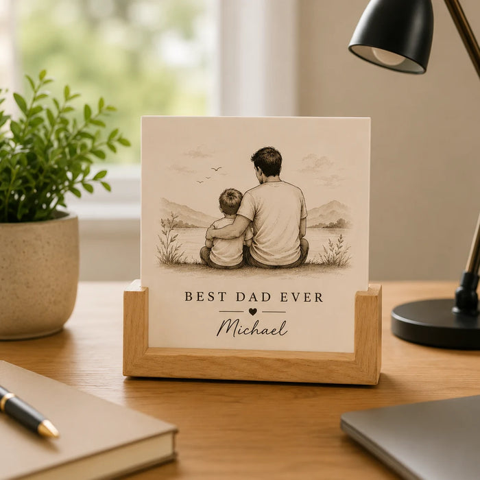 Personalized photo plaque with 'Best Dad Ever' on a desk with a plant and lamp in the background.